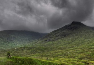 Green shades of Scottish hills juxtapose an ominous sky just before a storm.